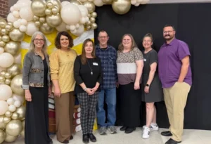 Aurora Downtown Project members in front of a balloon arch at the Aurora Chamber of Commerce banquet