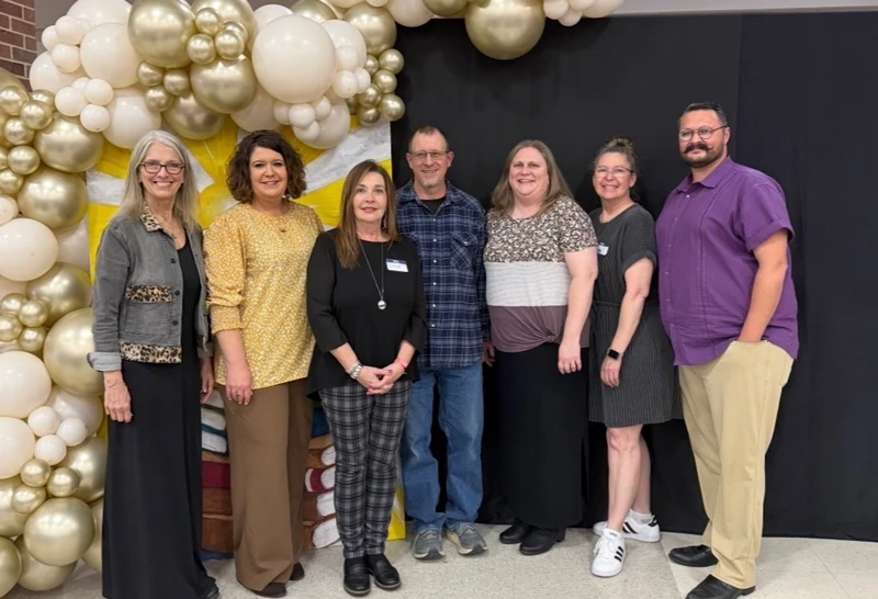 Aurora Downtown Project members in front of a balloon arch at the Aurora Chamber of Commerce banquet