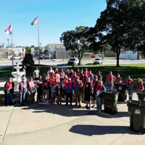Volunteers in red shirts gathered by the downtown fountain on Community Cleanup Day