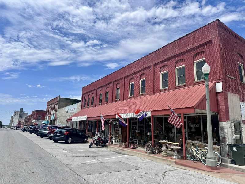 Red-brick historic block of downtown Aurora storefronts under a wide sky